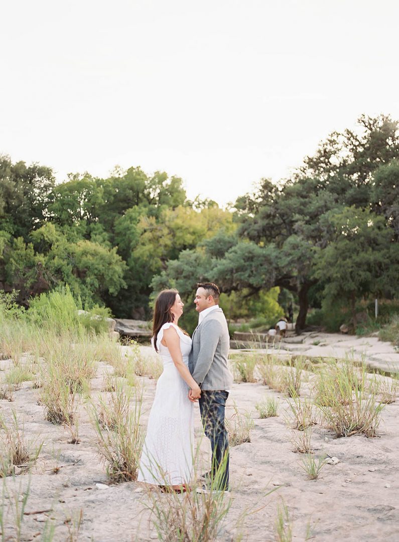 couple stands together for their engagement photos at Bull Creek