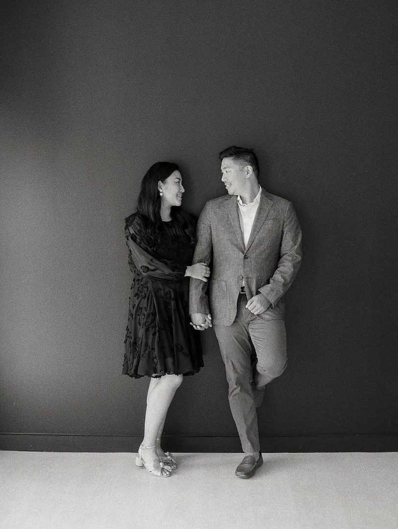 Black and white engagement photo of a couple posing together at the Lumen Room