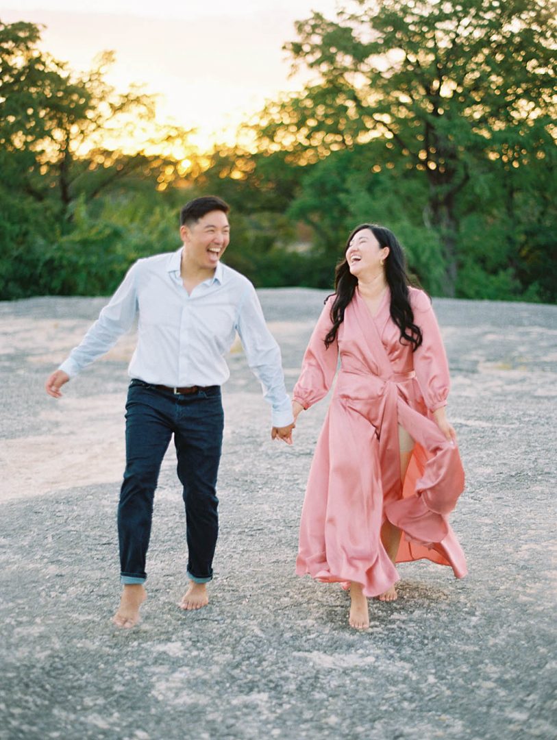 Engagement photo of a couple running and laughing