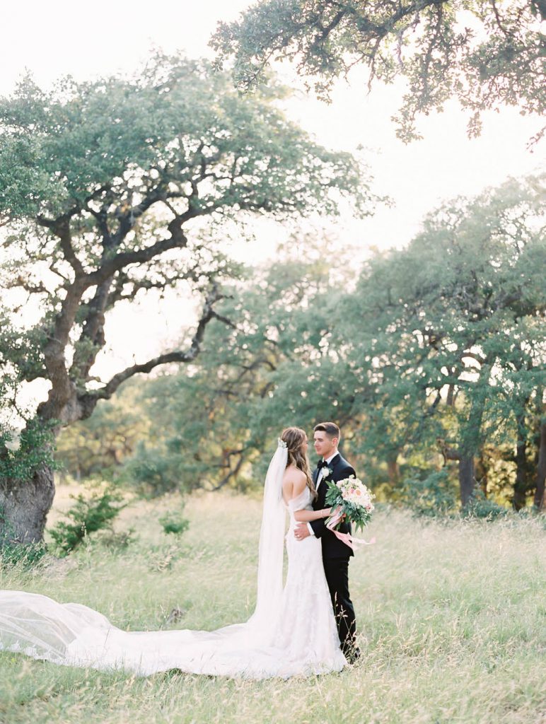 the newlyweds pose together in the texas hill country