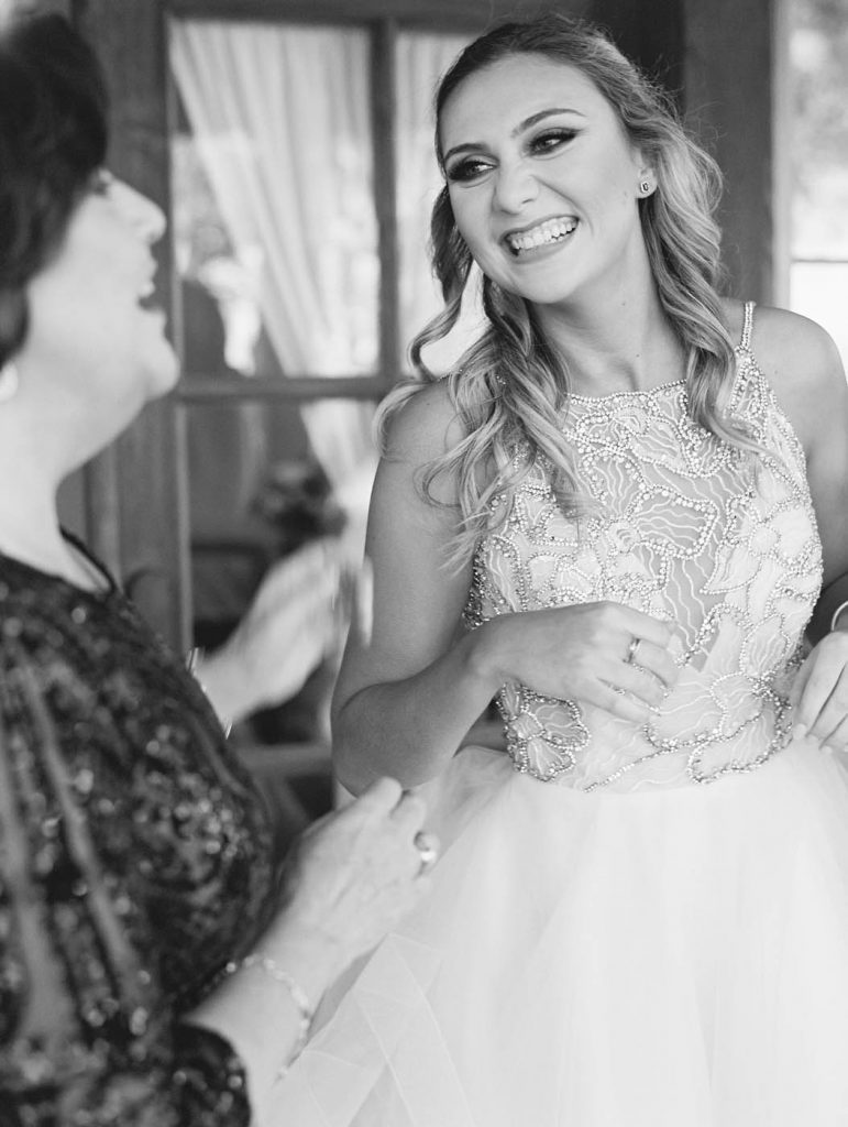 bride laughs while getting ready with mom