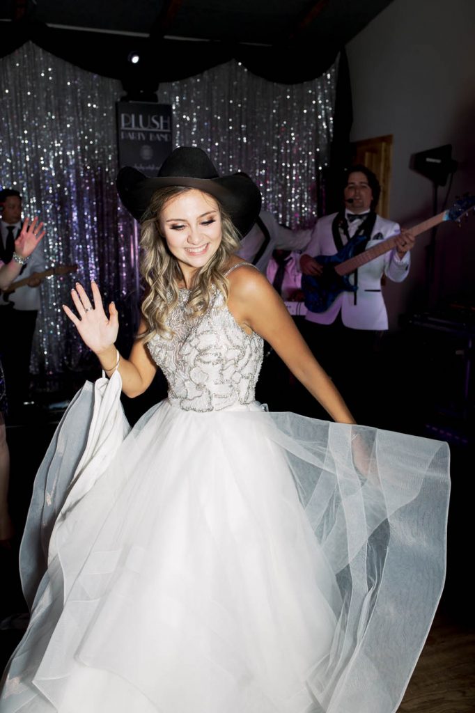 The bride dons a cowboy hat on the dance floor