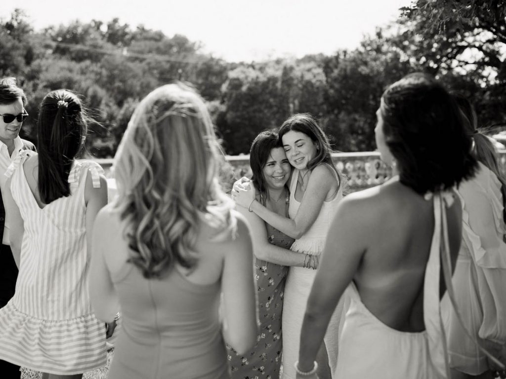 The bride hugs her friend in black and white