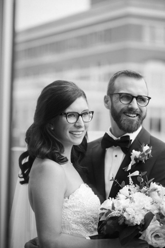 Black and white candid of wedding couple with glasses