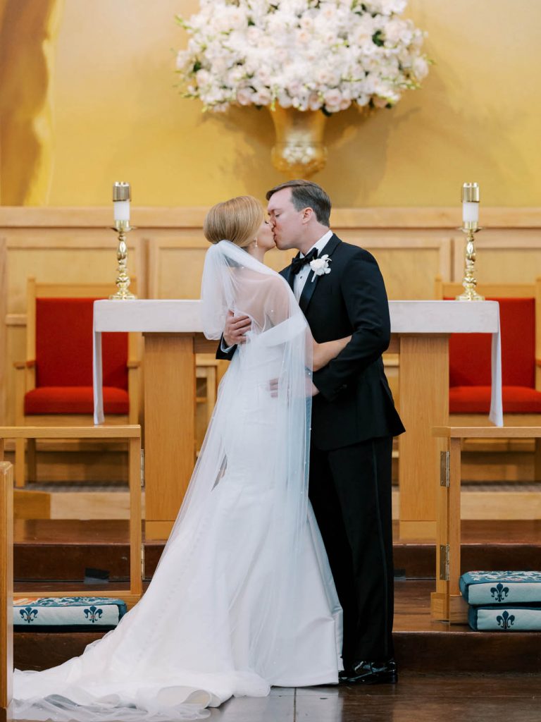 The newlyweds kiss at All Saints Chapel