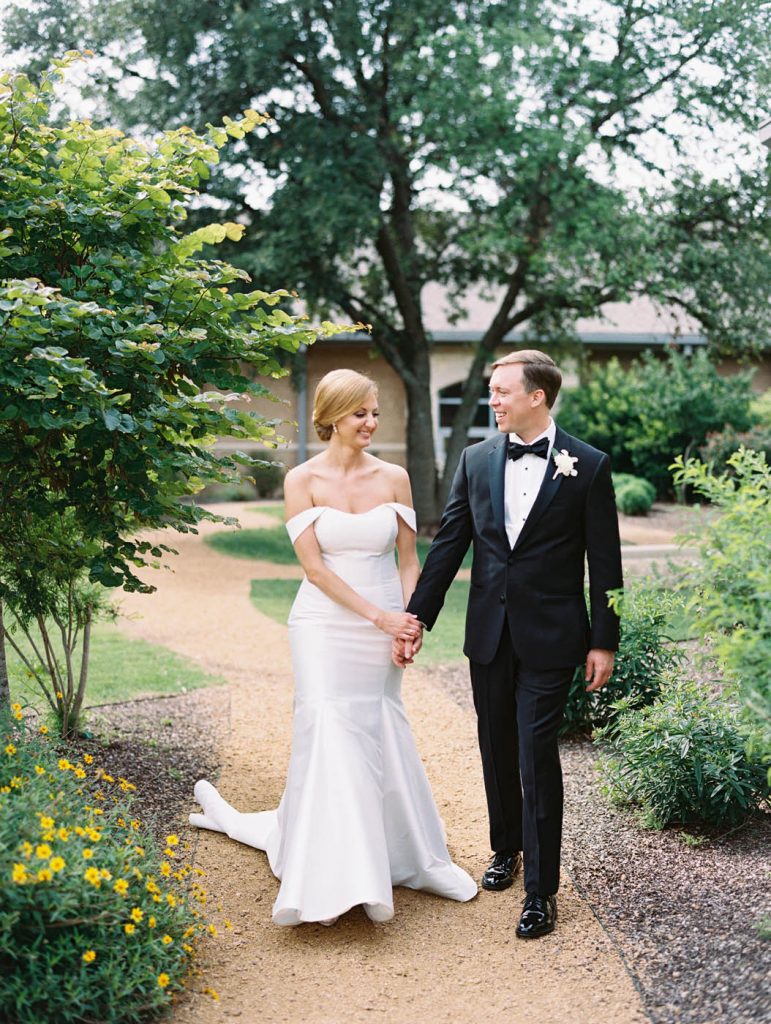 bride and groom walk together at All Saints Chapel