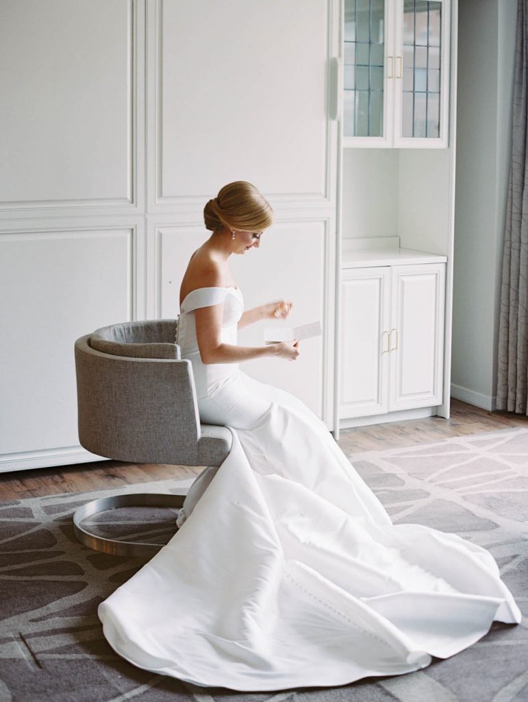 the bride reads a letter in her Stella York dress