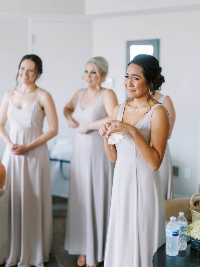 a bridesmaid gets emotional at seeing the bride fully dressed