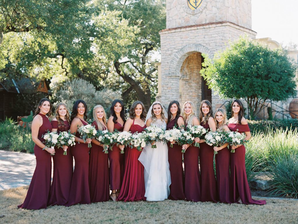 bride and bridesmaids lined up in maroon dresses
