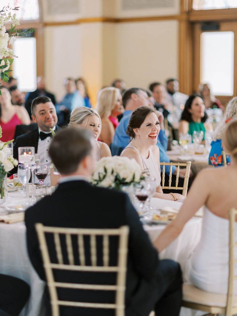 A bridesmaid laughs during a speech