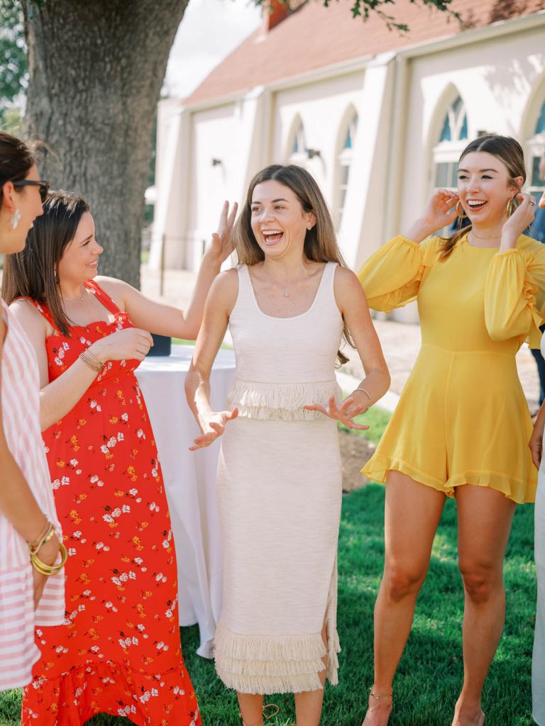 The bride stands with her friends and is excited to be engaged