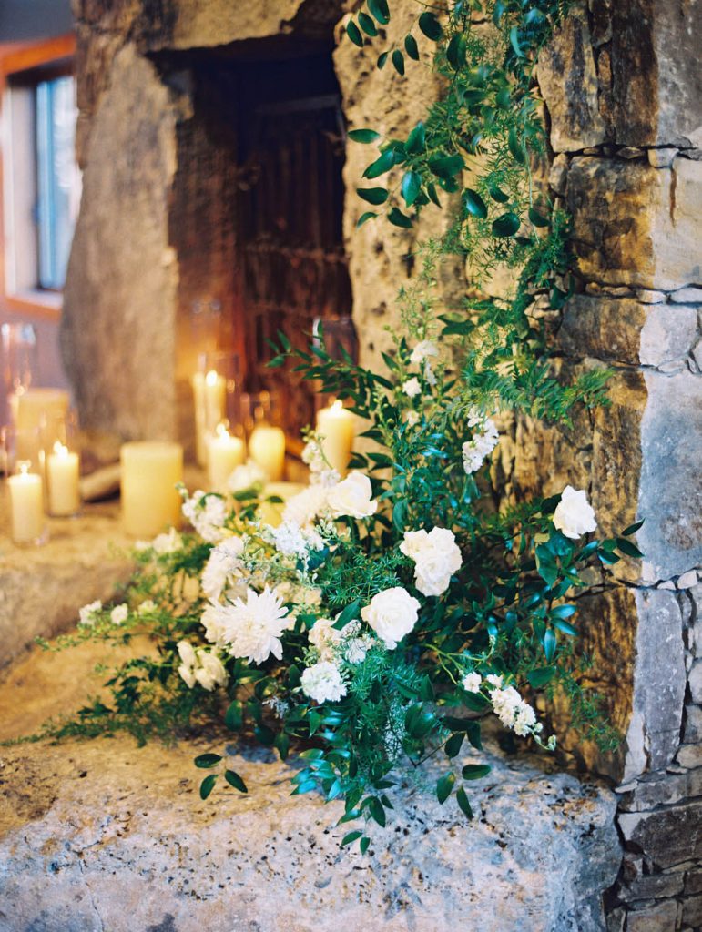 A floral installation on the candlelit fireplace