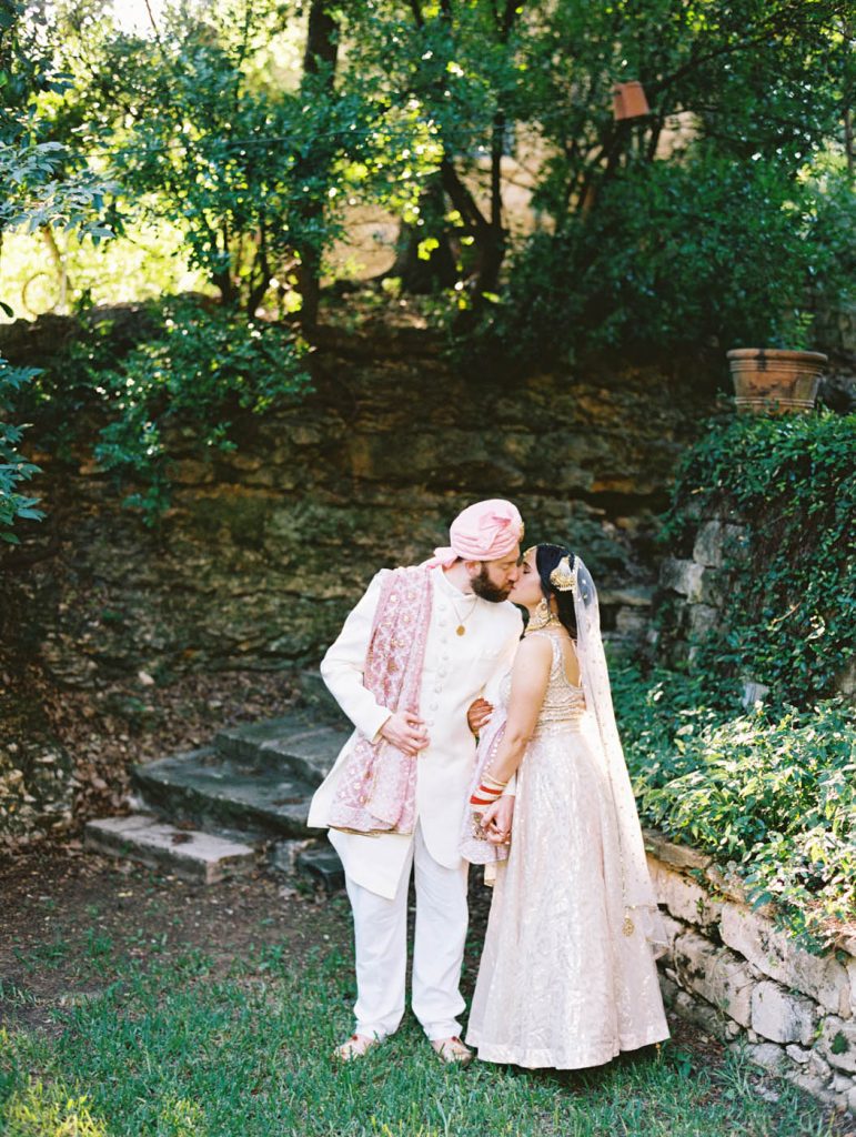 The Indian bride and groom share a kiss at Jennifer's Gardens