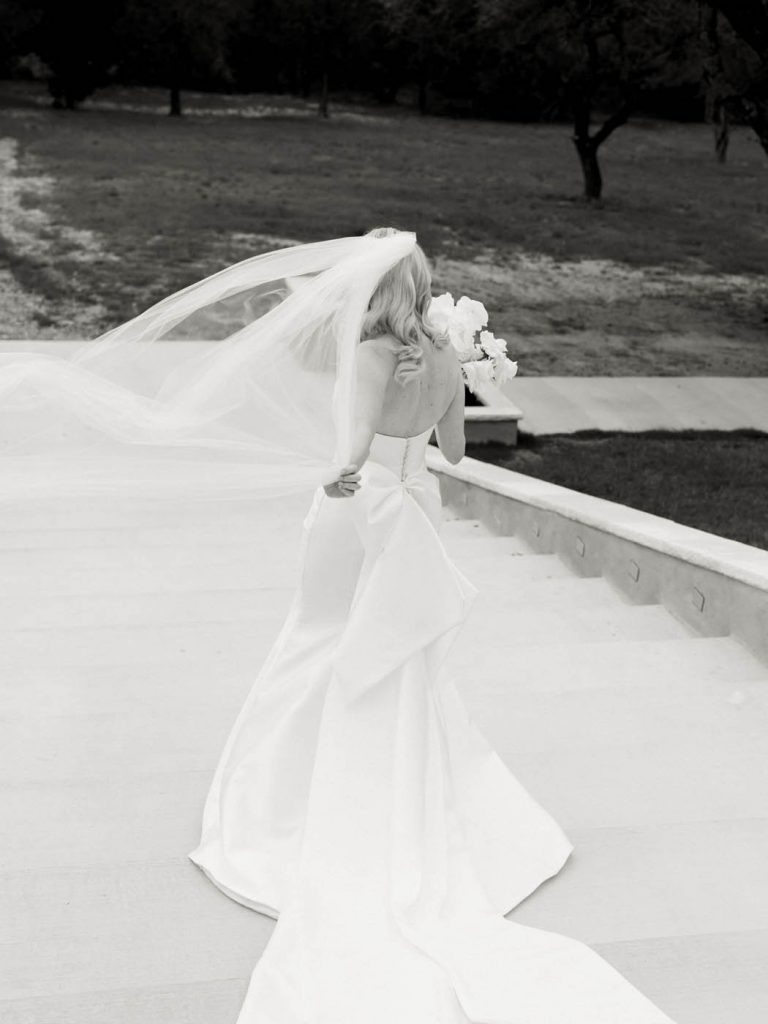bride walking down stairs and holding onto her veil