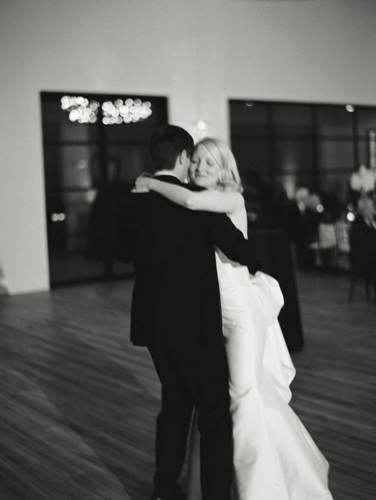 blurry photo of bride and groom hugging while having first dance