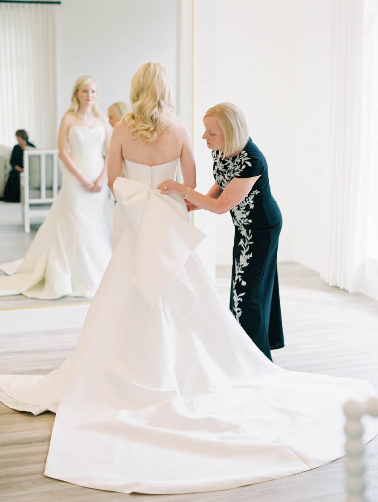 Bride putting on her Suzanne Neville dress at The Arlo
