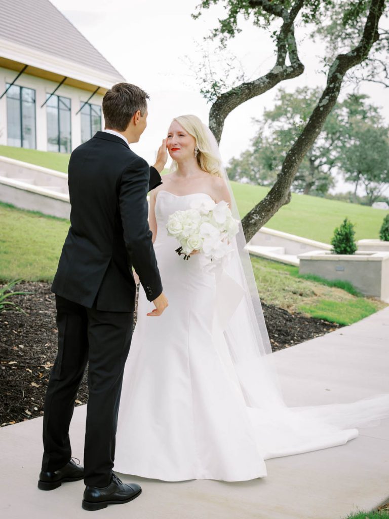 groom wipes a tear off the bride's face