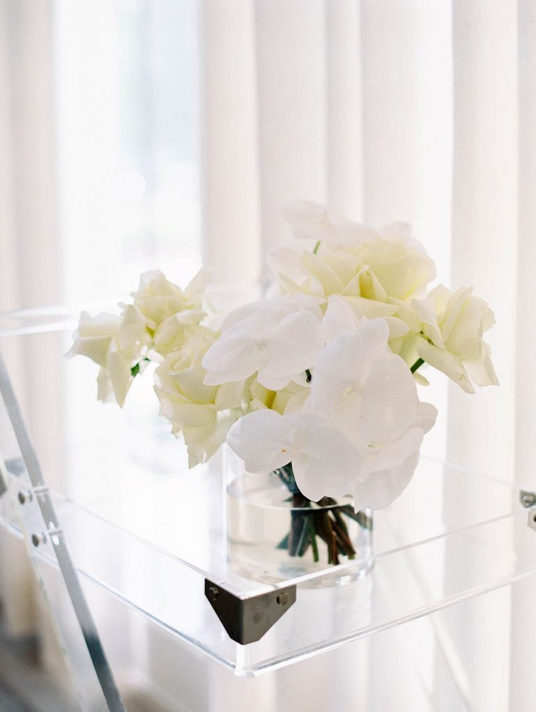 A white tonal bridal bouquet with roses and orchids