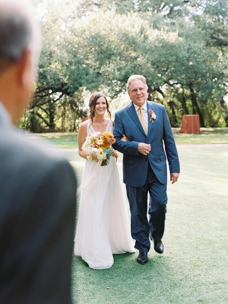 the bride being escorted down the aisle by her father