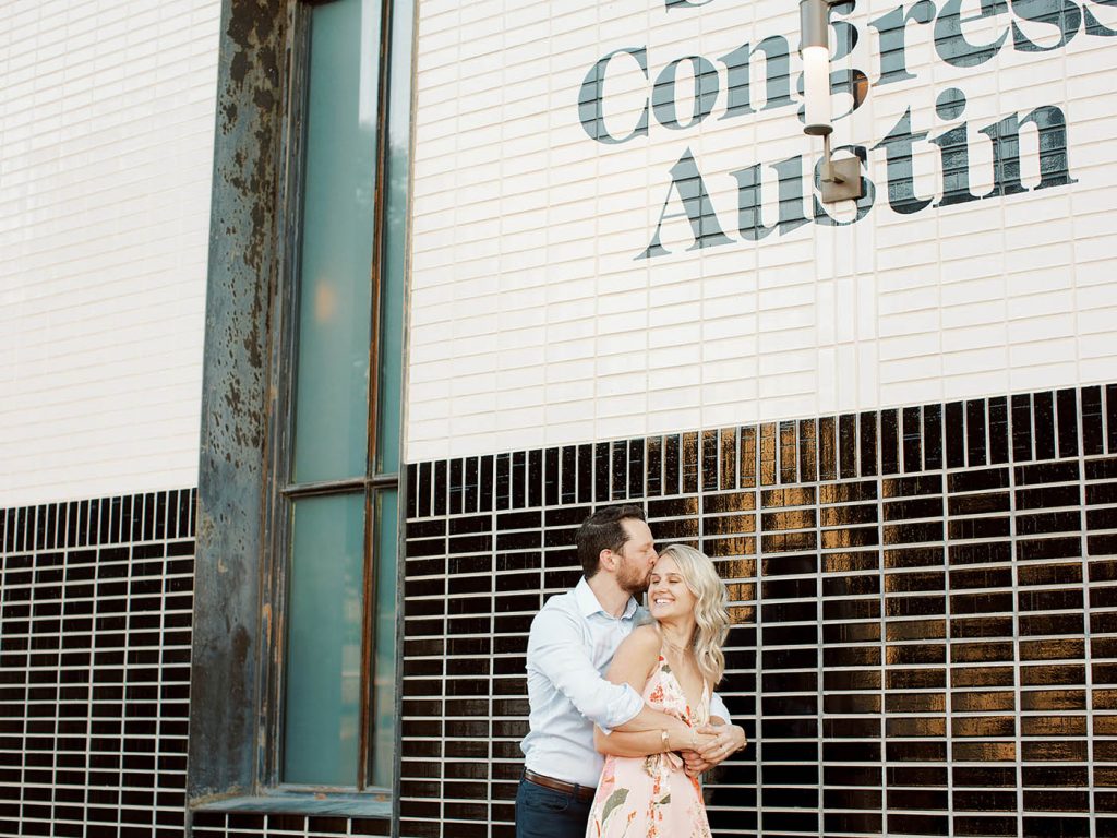 couple hugging in front of the south congress hotel
