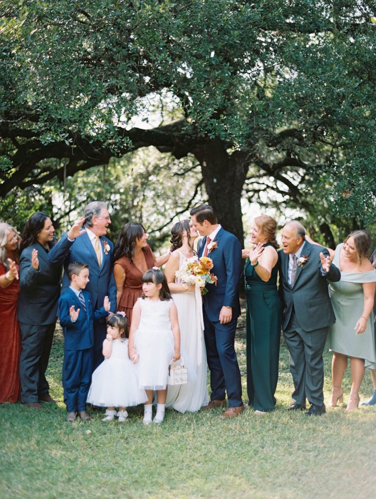 the couple kissing surrounded by their family