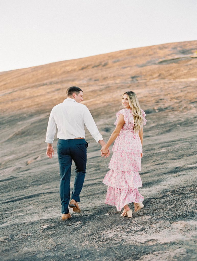 couple walking at enchanted rock for engagement photo