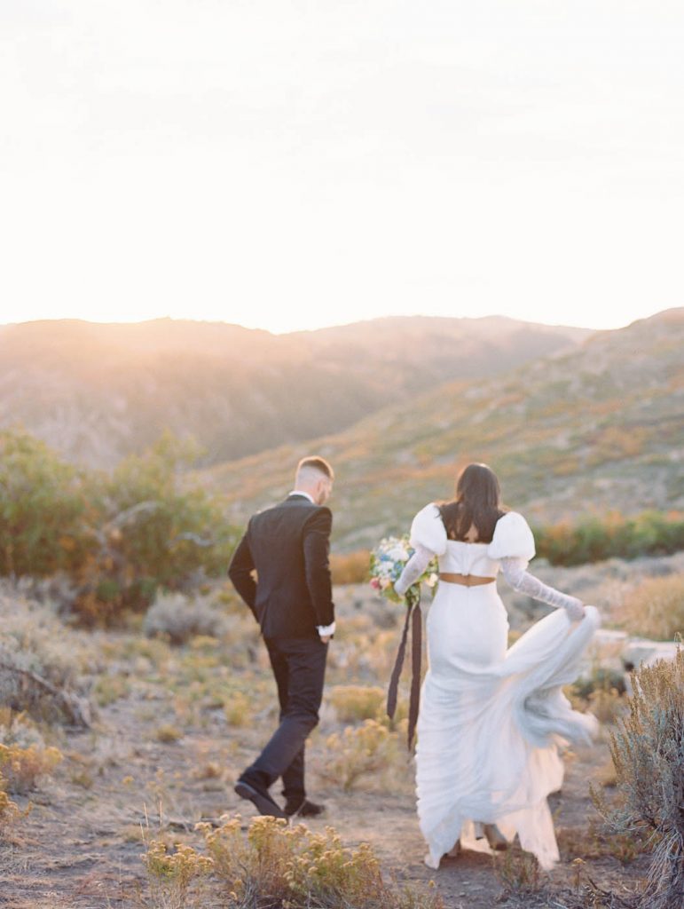 newlyed couple walking away in the mountains of Utah