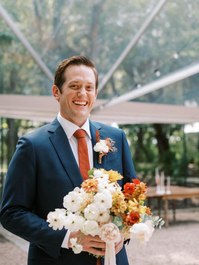 a candid laugh from the groom during family portraits