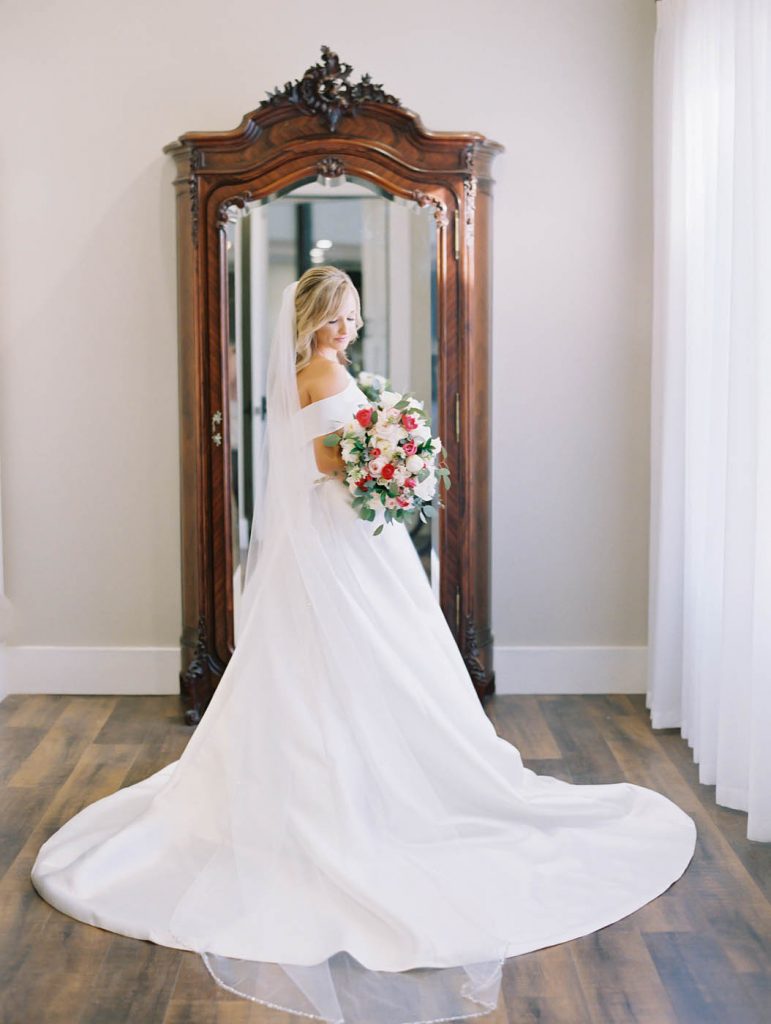 bride posing in the bridal suite of highpointe estate with her bouquet