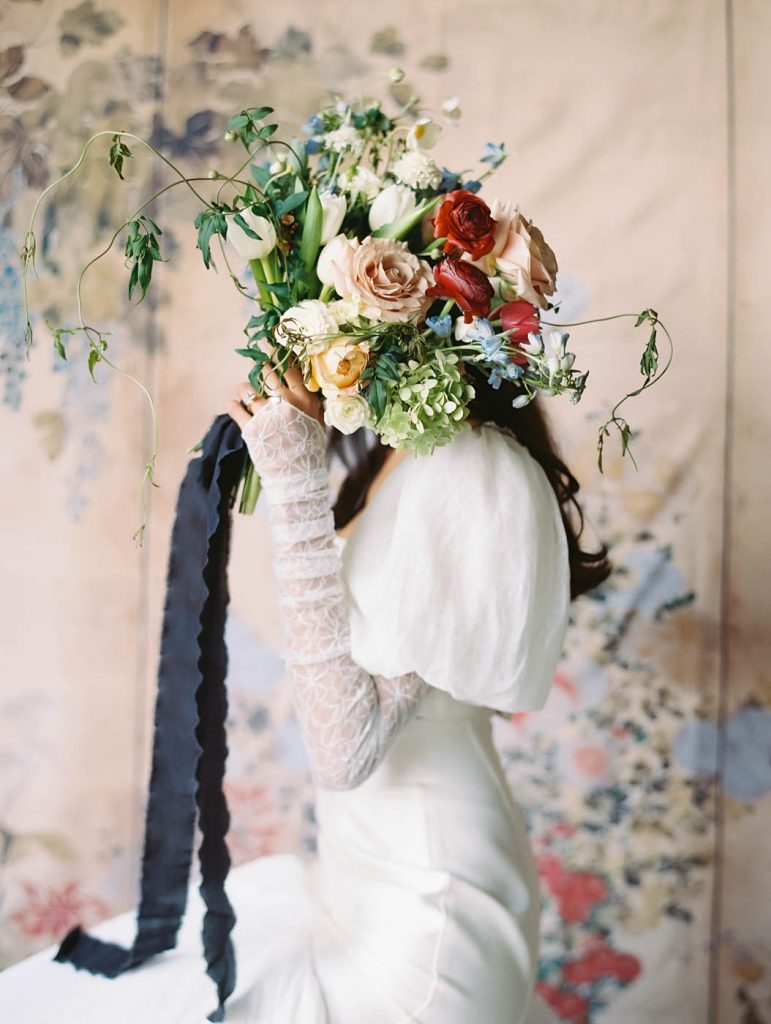an artistic portrait with the bouquet covering the bride's face