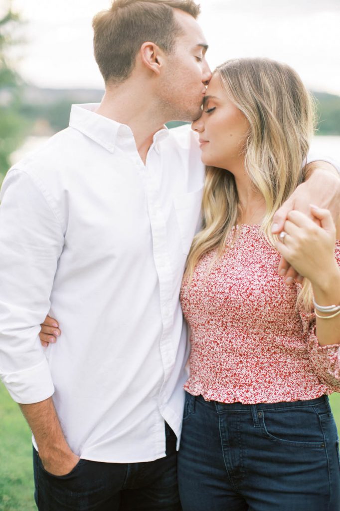 man in white shirt kisses woman in pink shirt