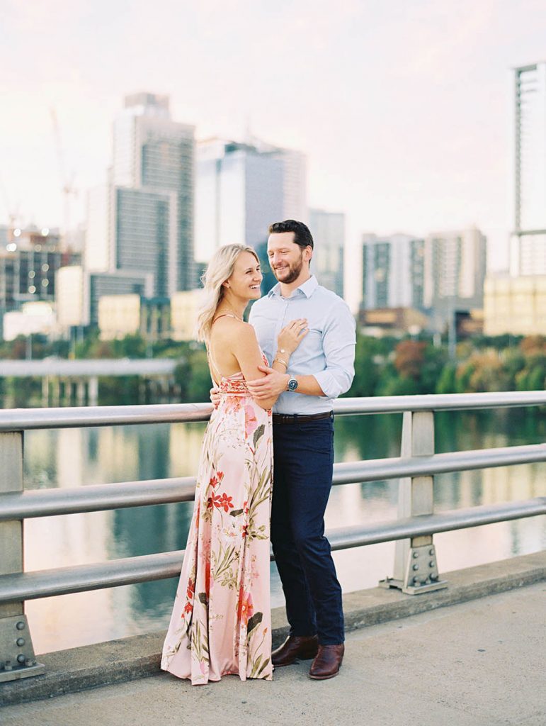 couple poses together for an engagement photo at the South Congress bridge