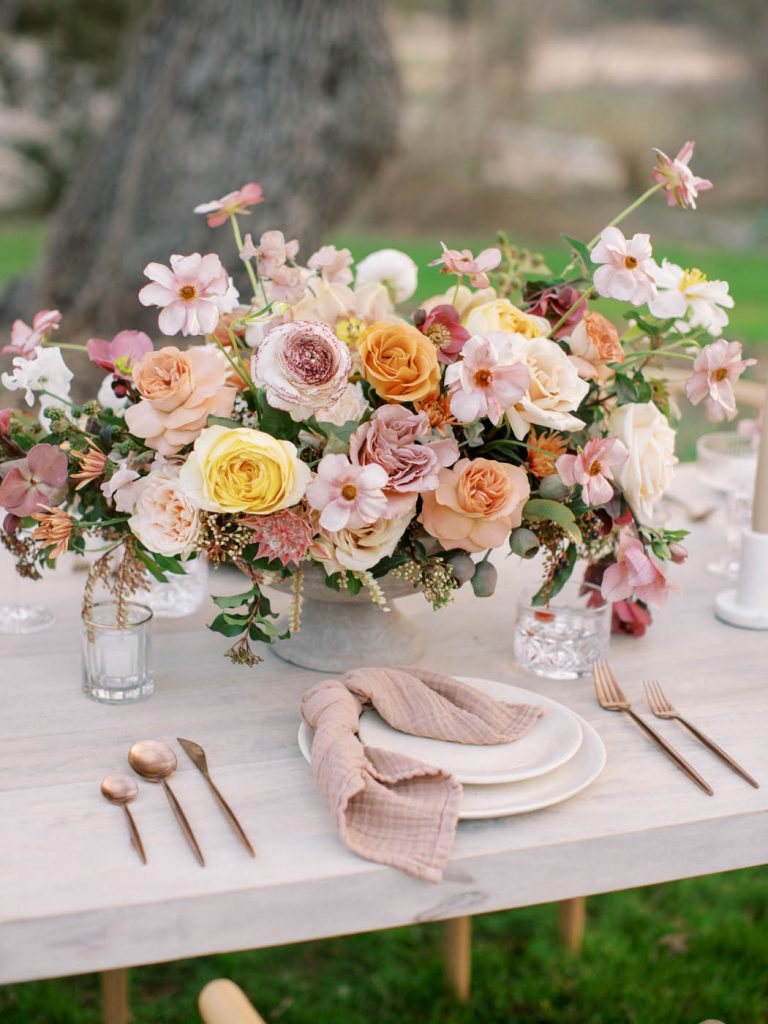 romantic place setting with flowers in shades of pink and orange