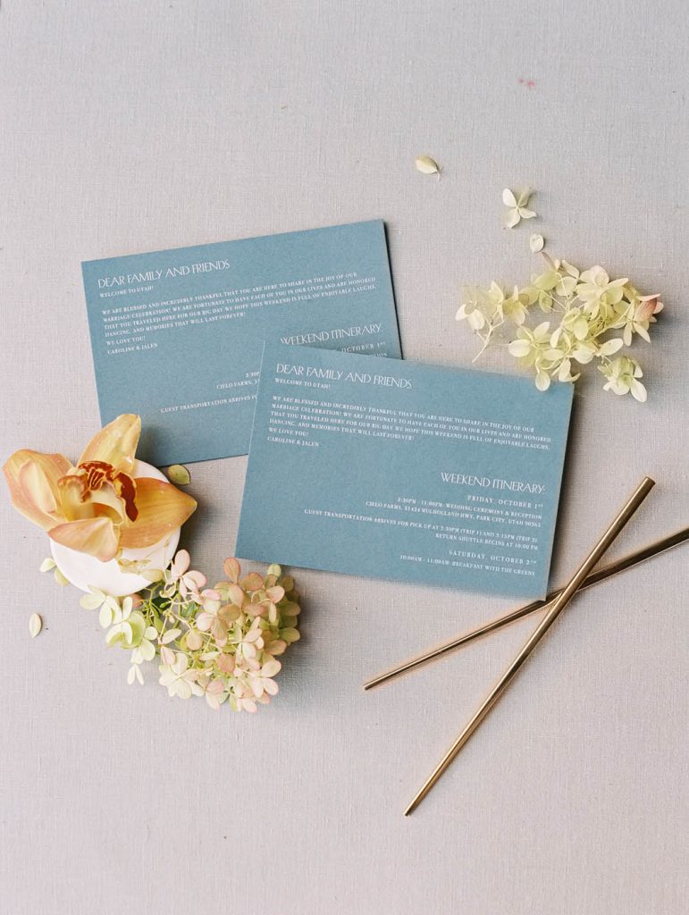 blue welcome card styled with flowers and gold chopsticks