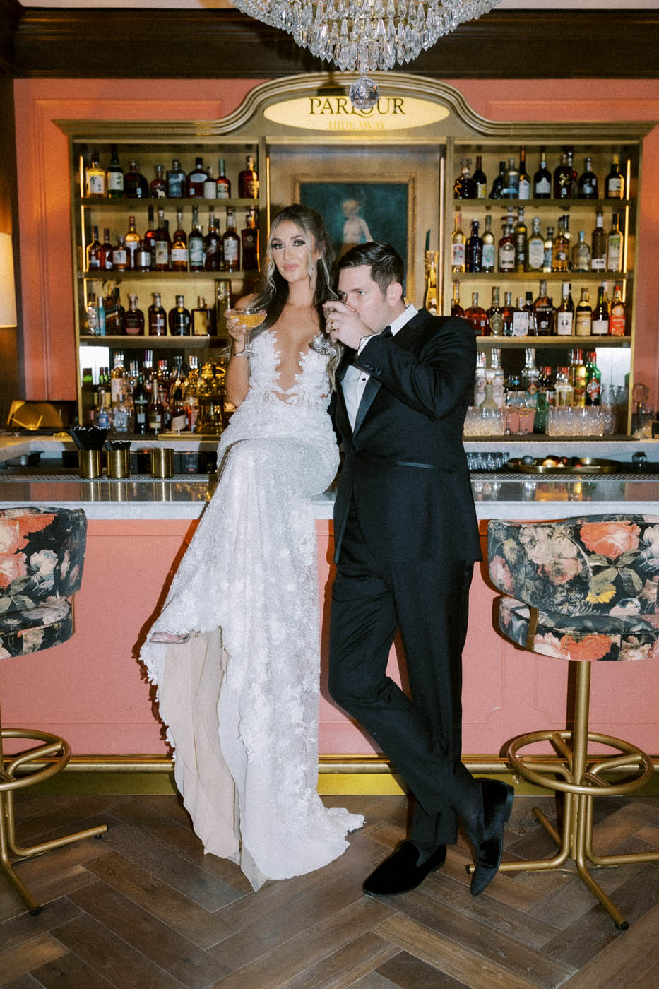 the bride and groom pose together on the bar in the C Baldwin Hotel's secret ladies lounge