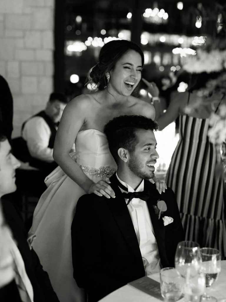 candid photo of the bride laughing with her hands on the shoulder of a guest