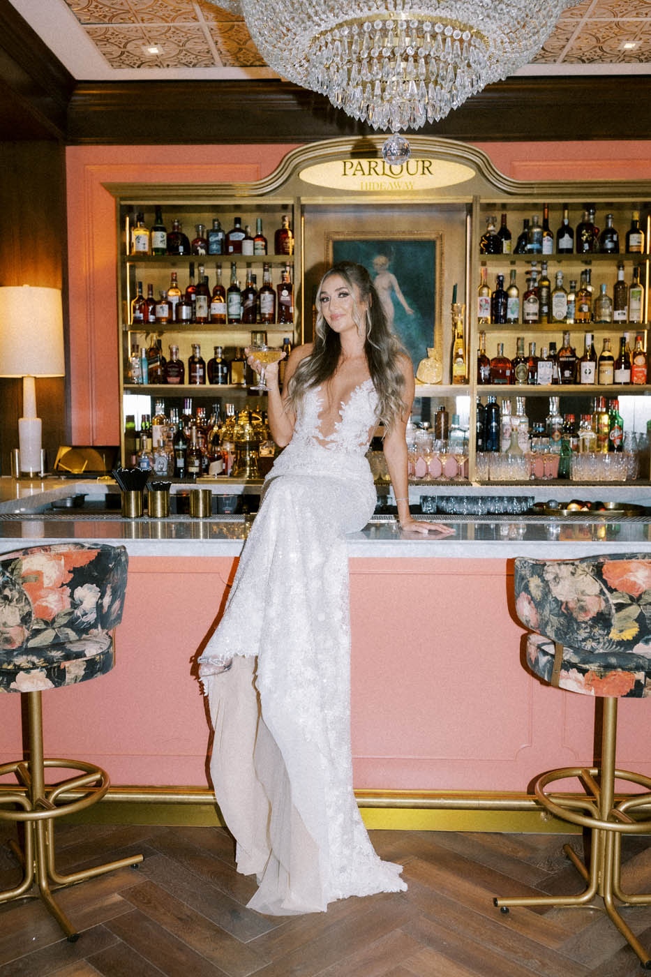 the bride poses on the bar in her Ines Disanto wedding dress