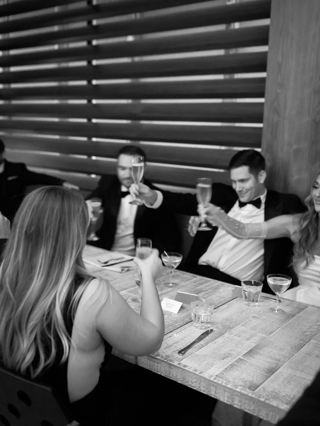 the bride and groom toast with their guests at dinner