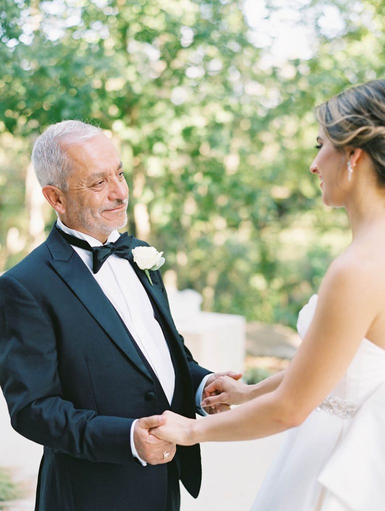 the father of the bride holds her hand while giving her some sage advice