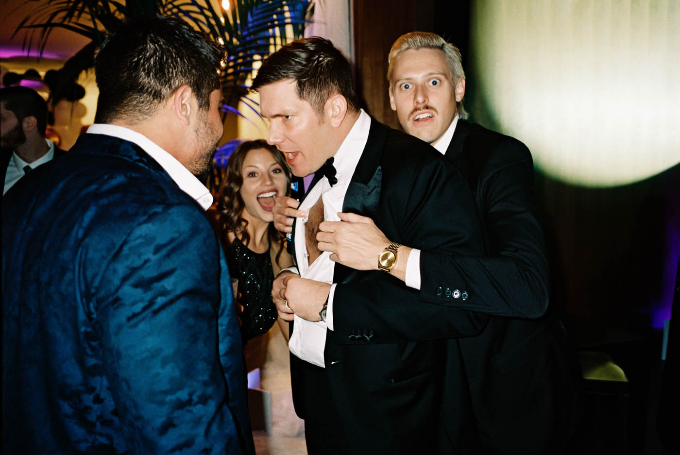 the groom's shirt is pulled open by a humorous guest