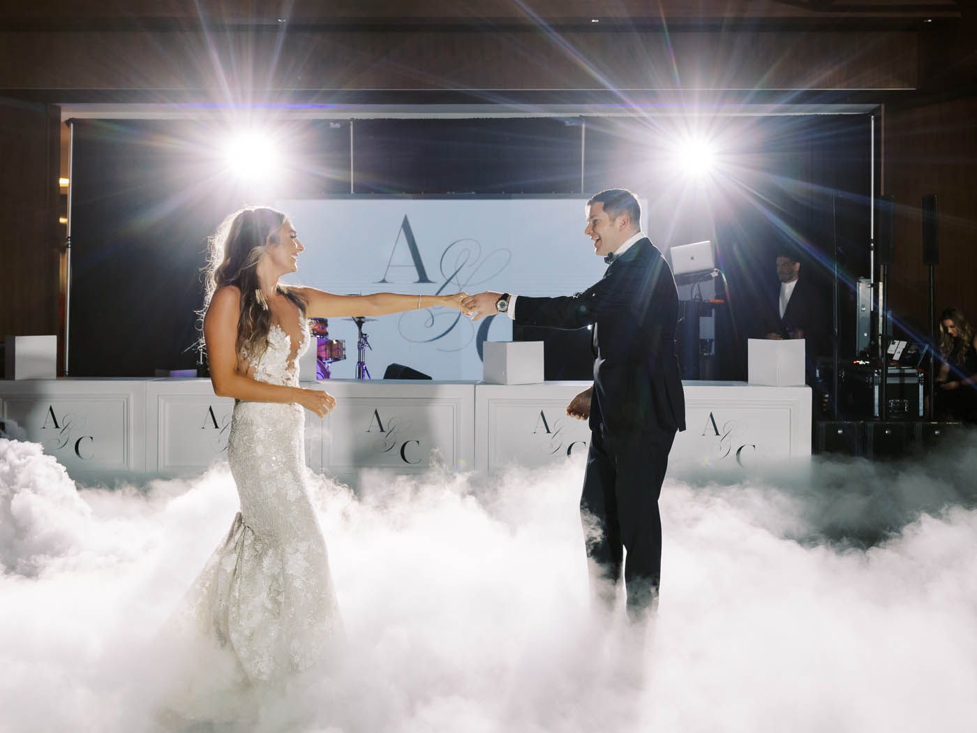 the couple shares their first dance as smoke fills the dance floor