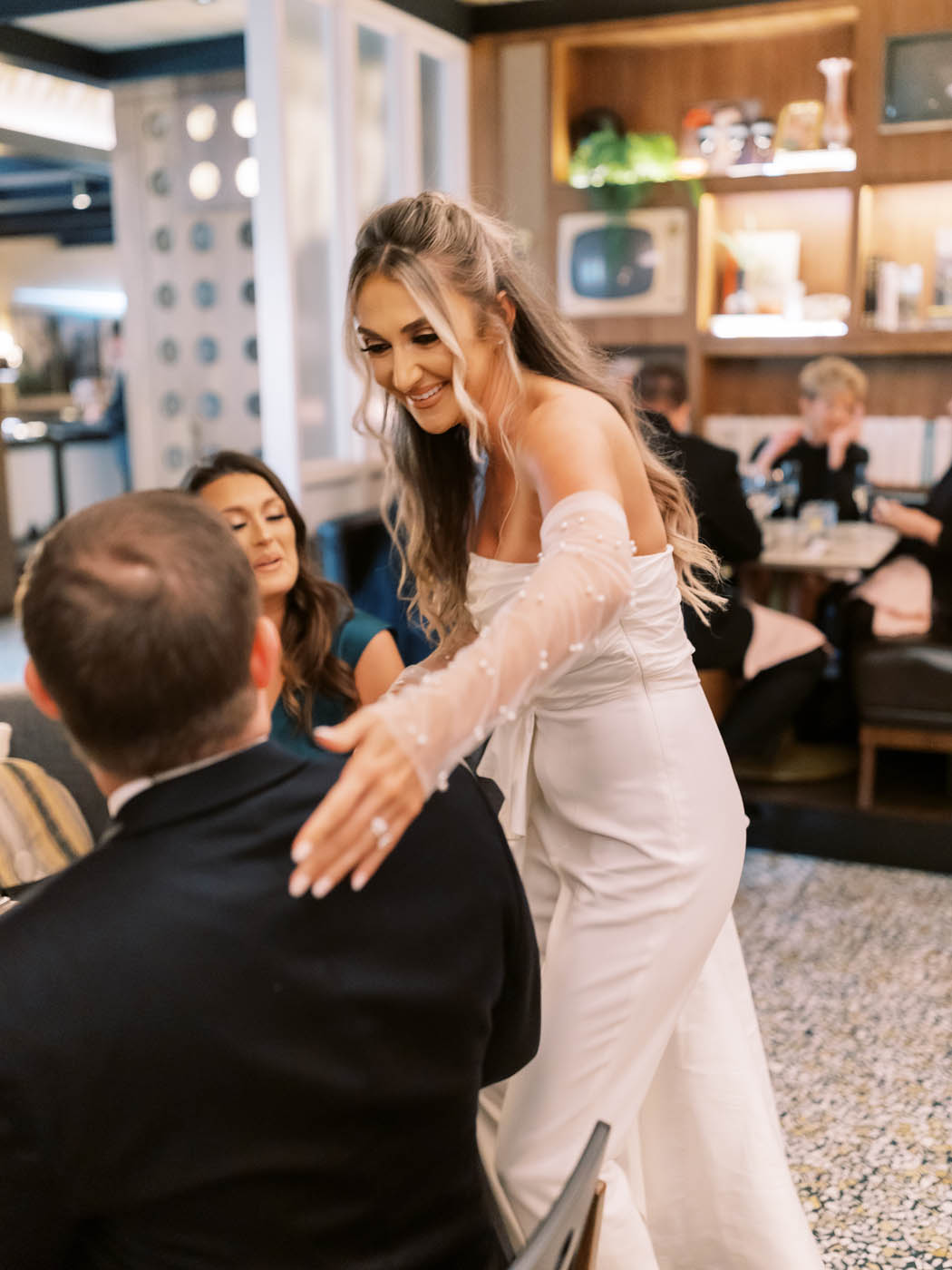 bride greeting her guests in her jay godfrey bridal jumpsuit