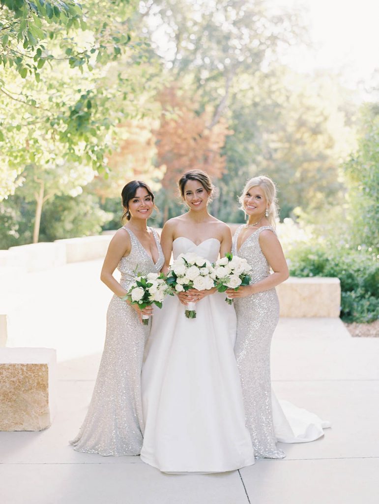 the bride poses with her two maids of honor
