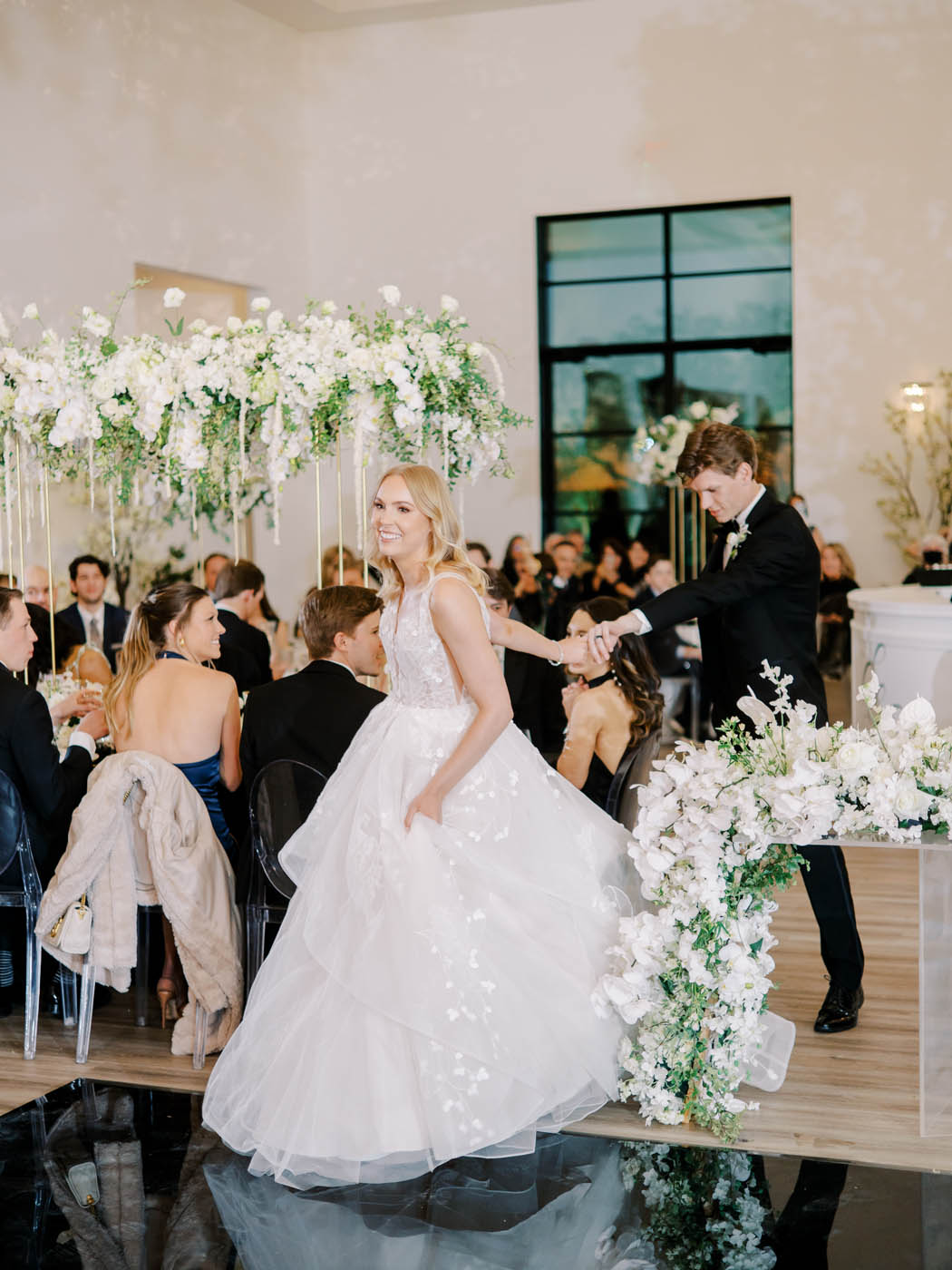 the bride leads the groom by the hand onto the dance floor for the grand entrance