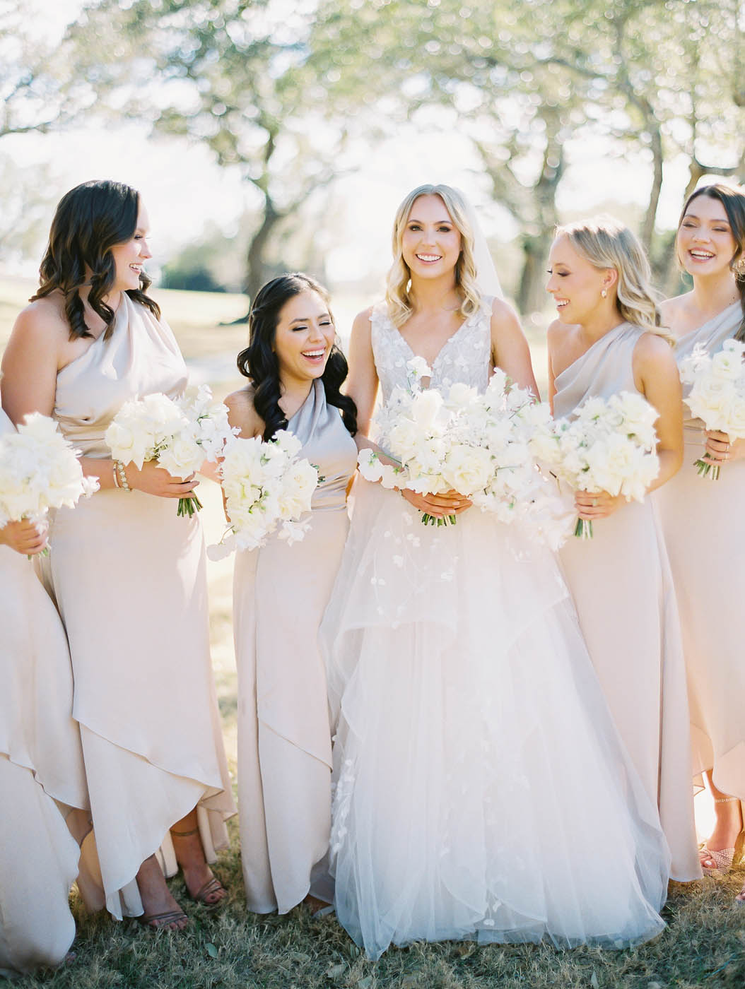 the bride laughs with her bridesmaids