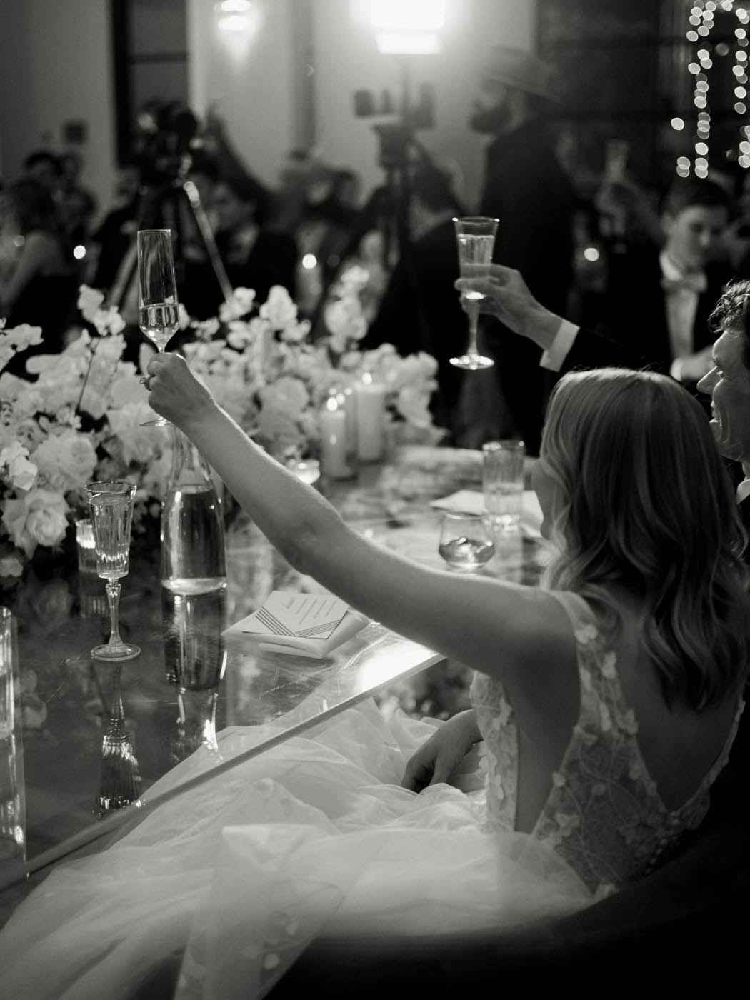 bride and groom raise their glasses to toast