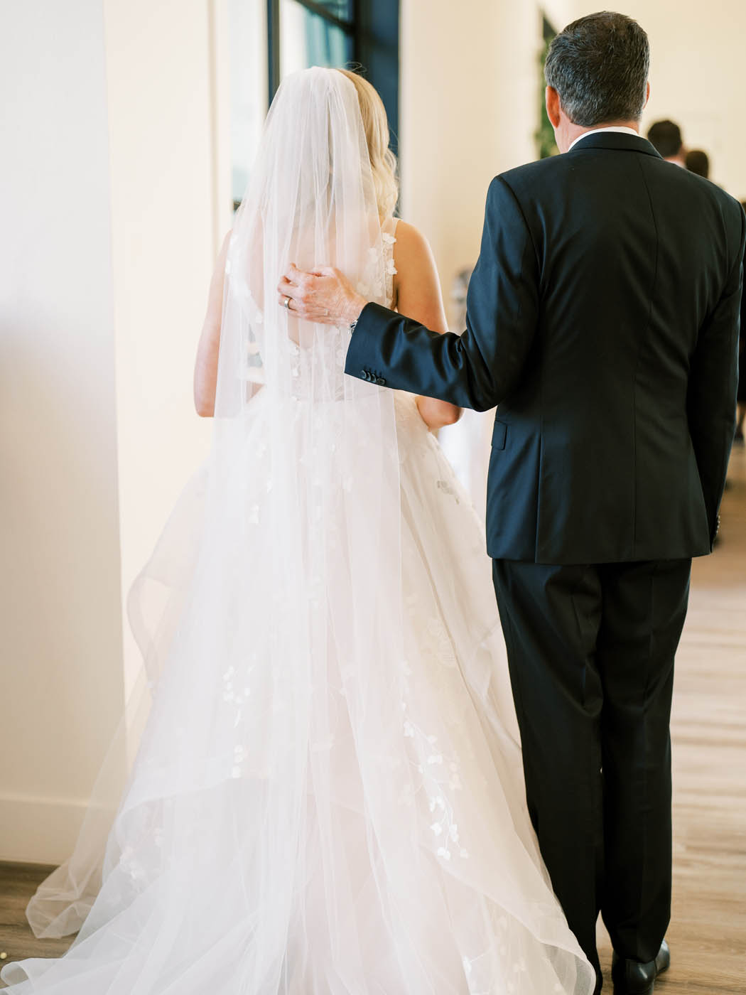 the bride and her father share a tender moment before she walks down the aisle