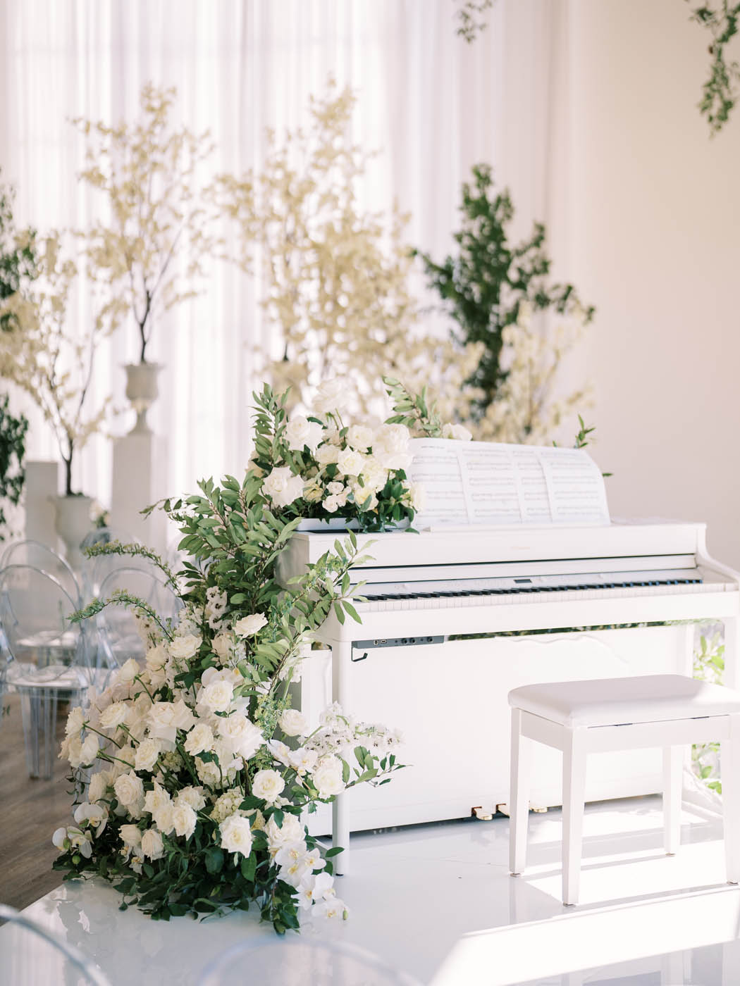 A white piano covered in white and green floral for a ceremony at The Arlo in Austin, Texas
