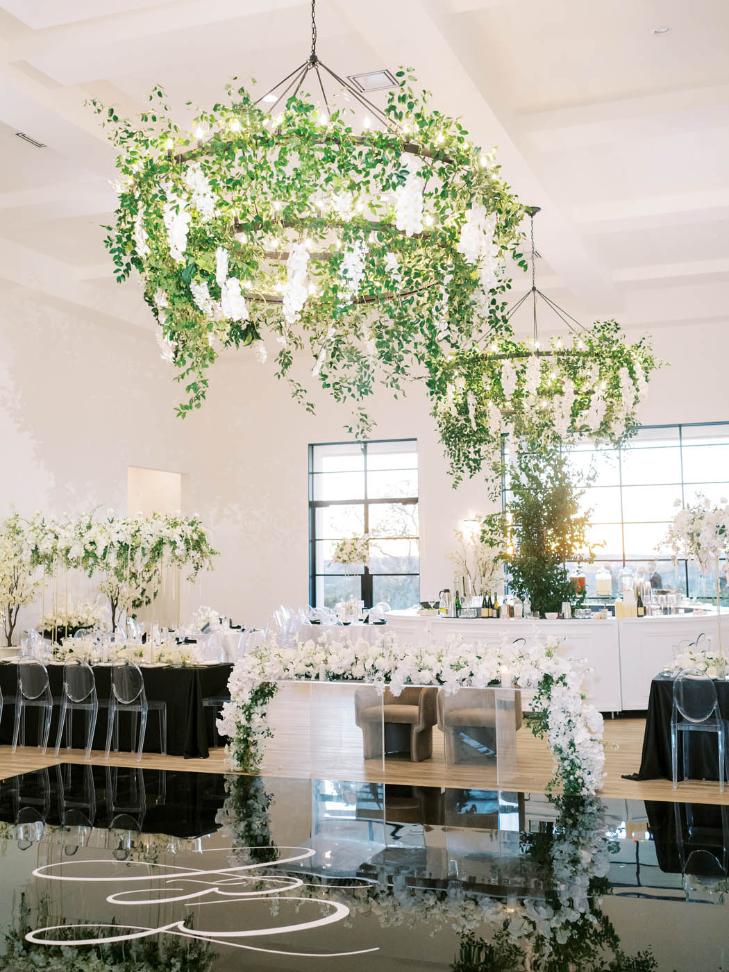 White and green florals drip down from the ceiling for this modern sleek reception